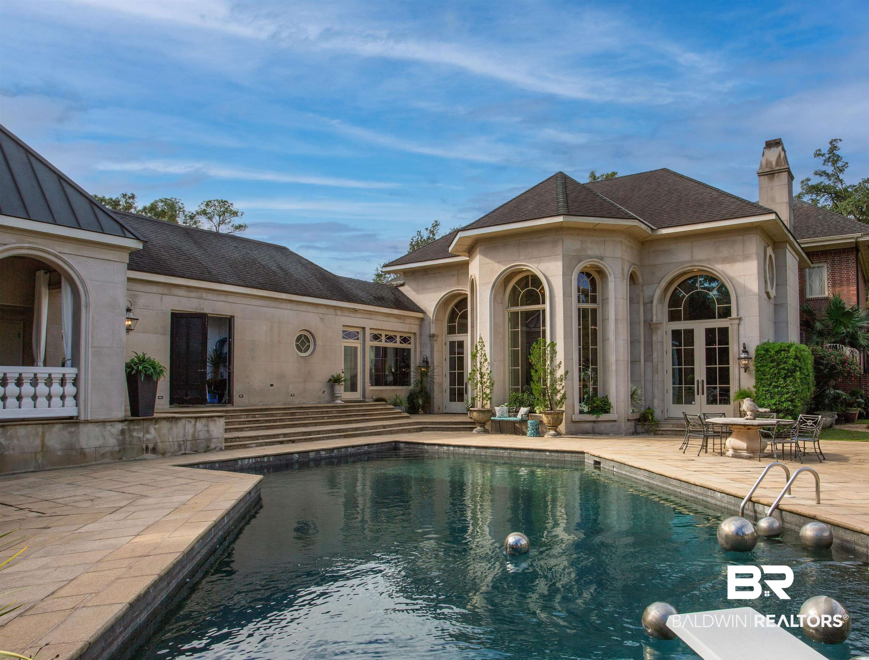 150 Austill Avenue Mobile, AL 36608 - Photo 38 of 39 Outdoor swimming pool with a diving board, surrounded by stone patio decking and tiered steps