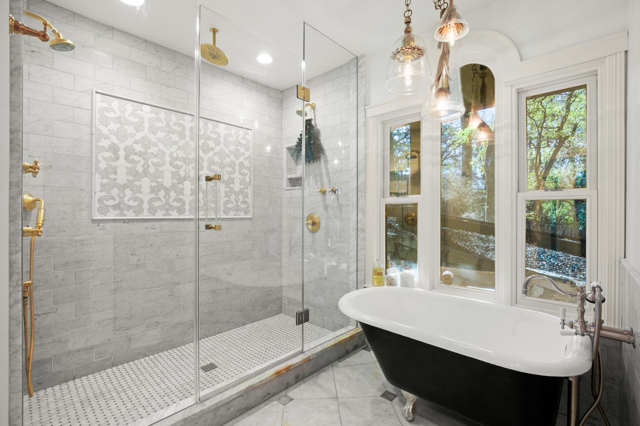1601 Whitney Way Austin, TX 78741 - Photo 18 of 30 A lavish primary bathroom with an ornate walk-in shower and a free-standing tub, illuminated by multiple large windows.