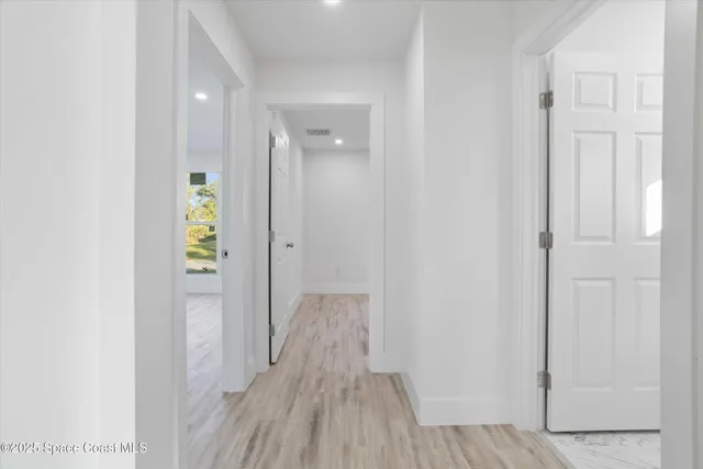 a view of hallway with wooden floor