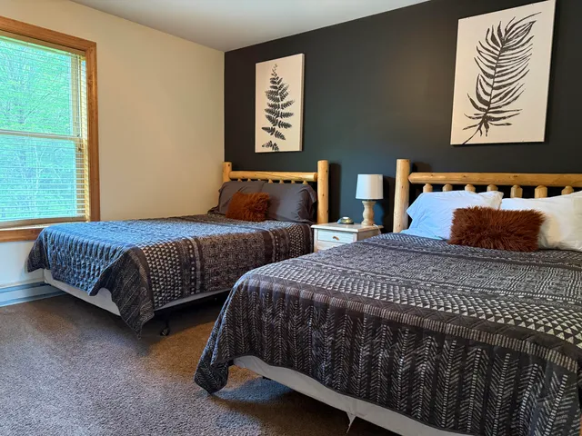 a bedroom with two beds and a window