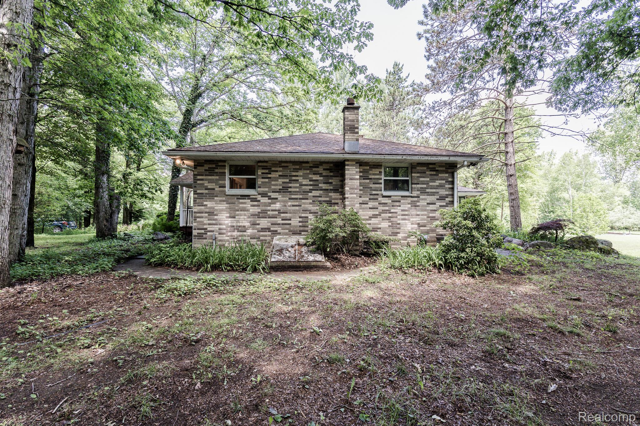 8197 Irish Road Millington, MI 48746 - Photo 12 of 38 Brick exterior with a shingled roof and prominent chimney