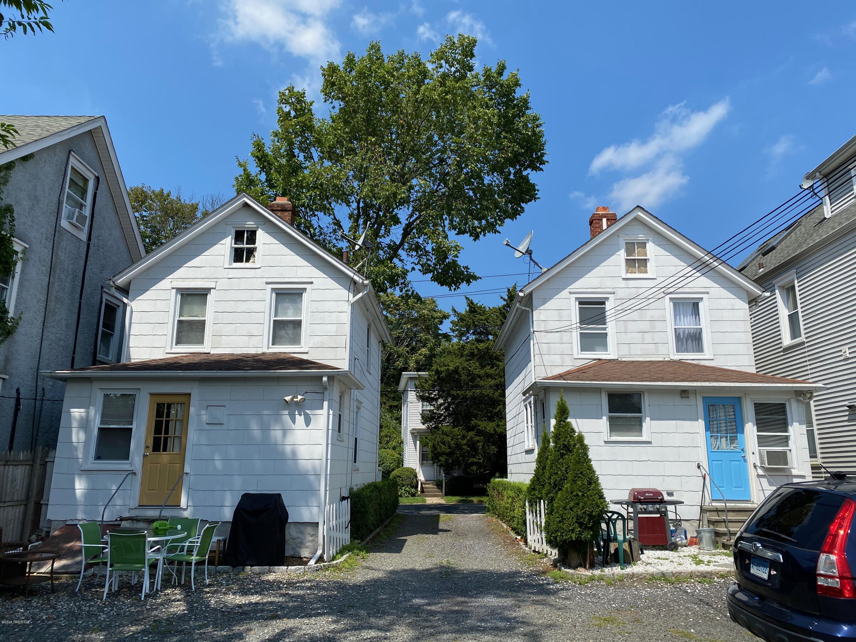22 Division Street Greenwich, CT 06830 - Photo 25 of 28 a view of a white house with large windows and a small yard