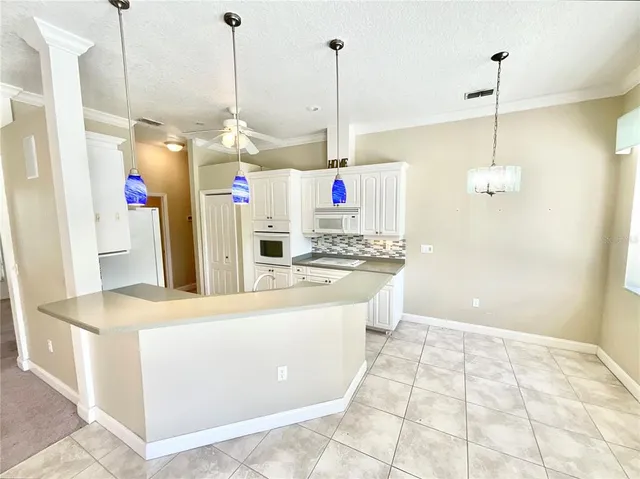 a large kitchen with stainless steel appliances kitchen island granite countertop a sink a counter and a view of living room