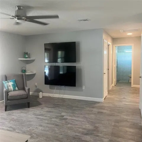a living room with furniture and a ceiling fan