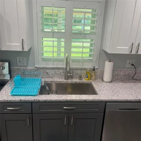 a kitchen with a sink cabinets and window
