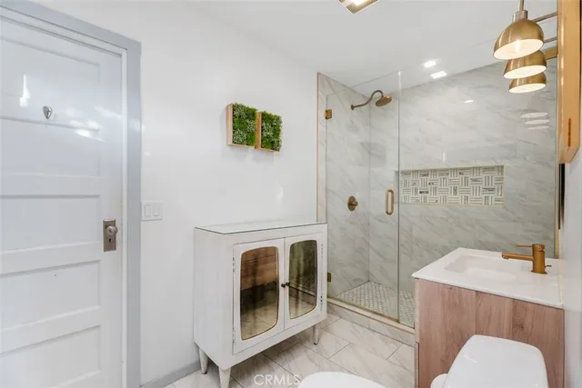 a bathroom with a sink a toilet and shower