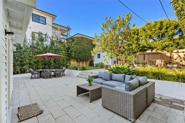 a view of a patio with couches and a table and chairs with potted plants