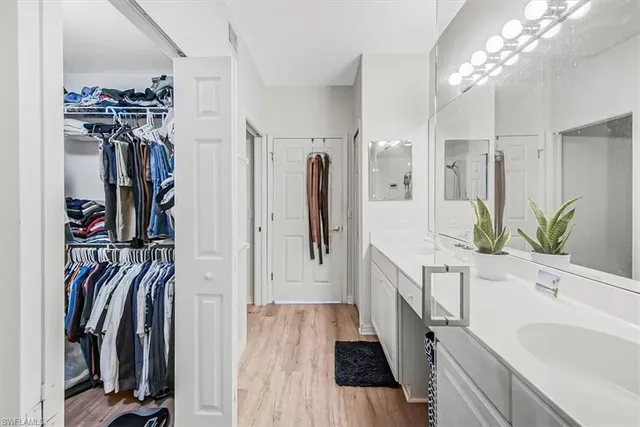 a spacious bathroom with a double vanity sink a mirror and shower