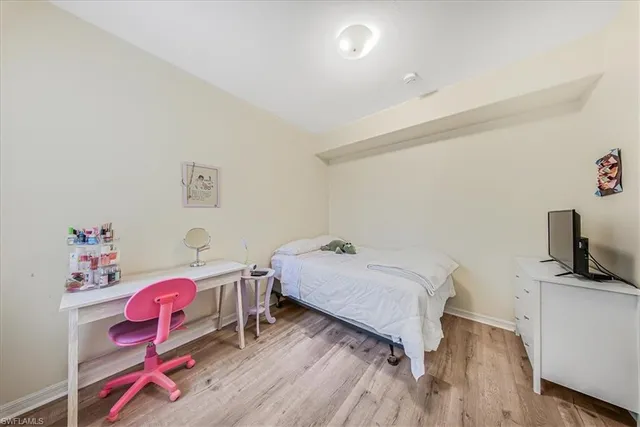 a bedroom with a bed and a flat tv screen on the dresser