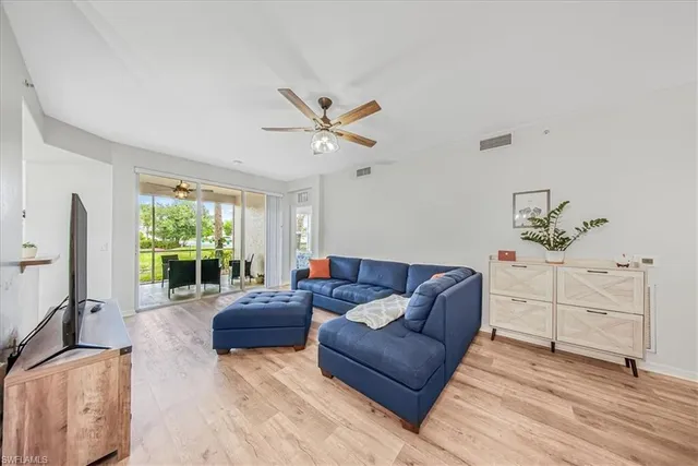 a living room with furniture a large window with wooden floor
