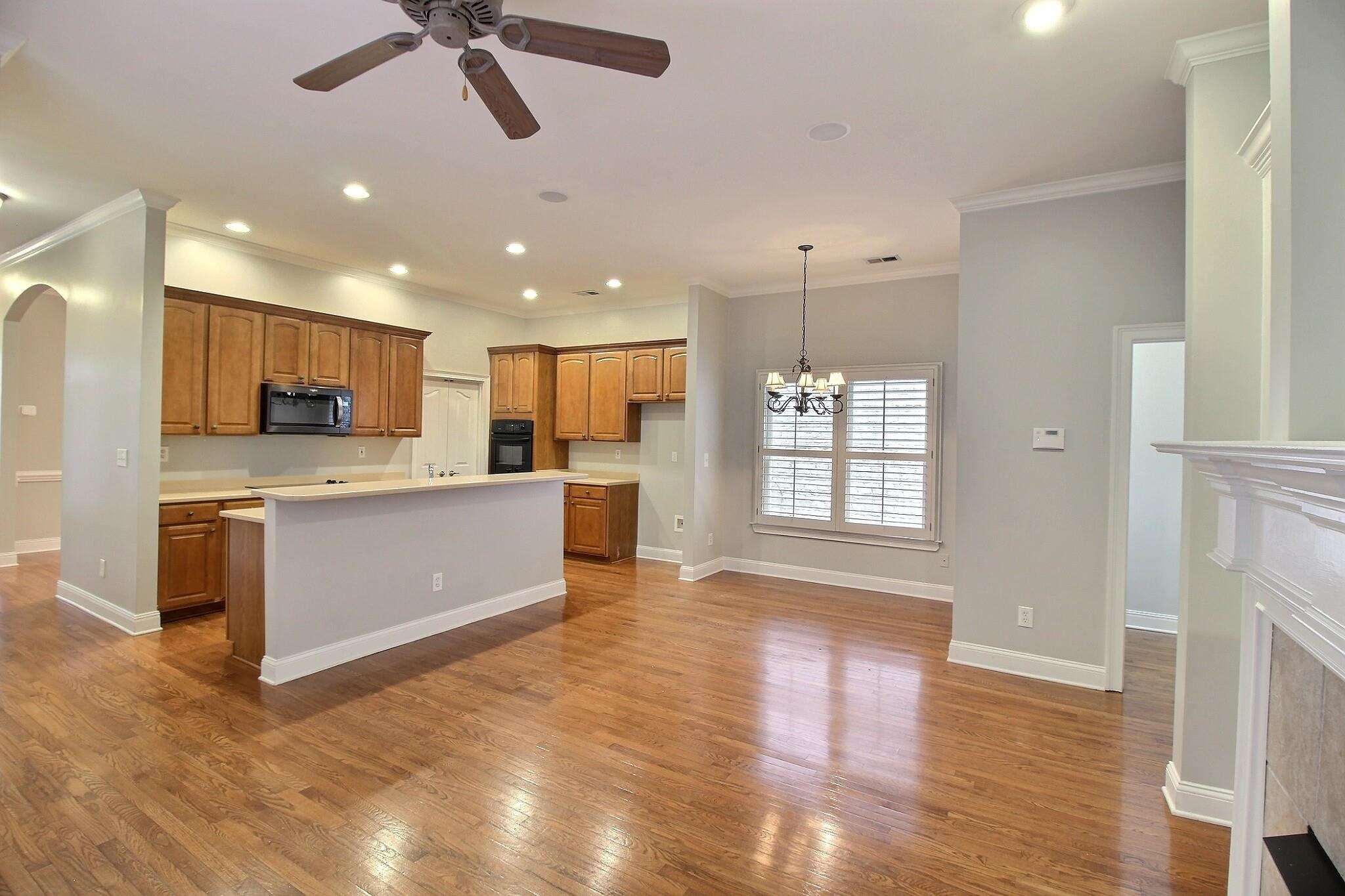 845 McFerrin Lane Collierville, TN 38017 - Photo 7 of 27 a large kitchen with a center island wooden floor stainless steel appliances and a window