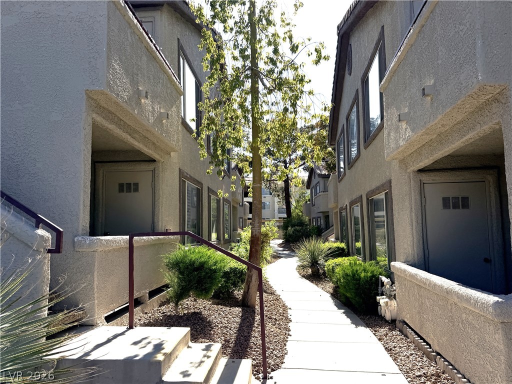 4955 South Lindell Road, Unit 203 Las Vegas, NV 89118 - Photo 28 of 31 A winding walkway guides residents through a verdant courtyard, framed by multi-story stucco structures.