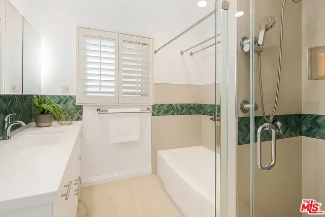 a bathroom with a tub a potted plant on the counter and a shower