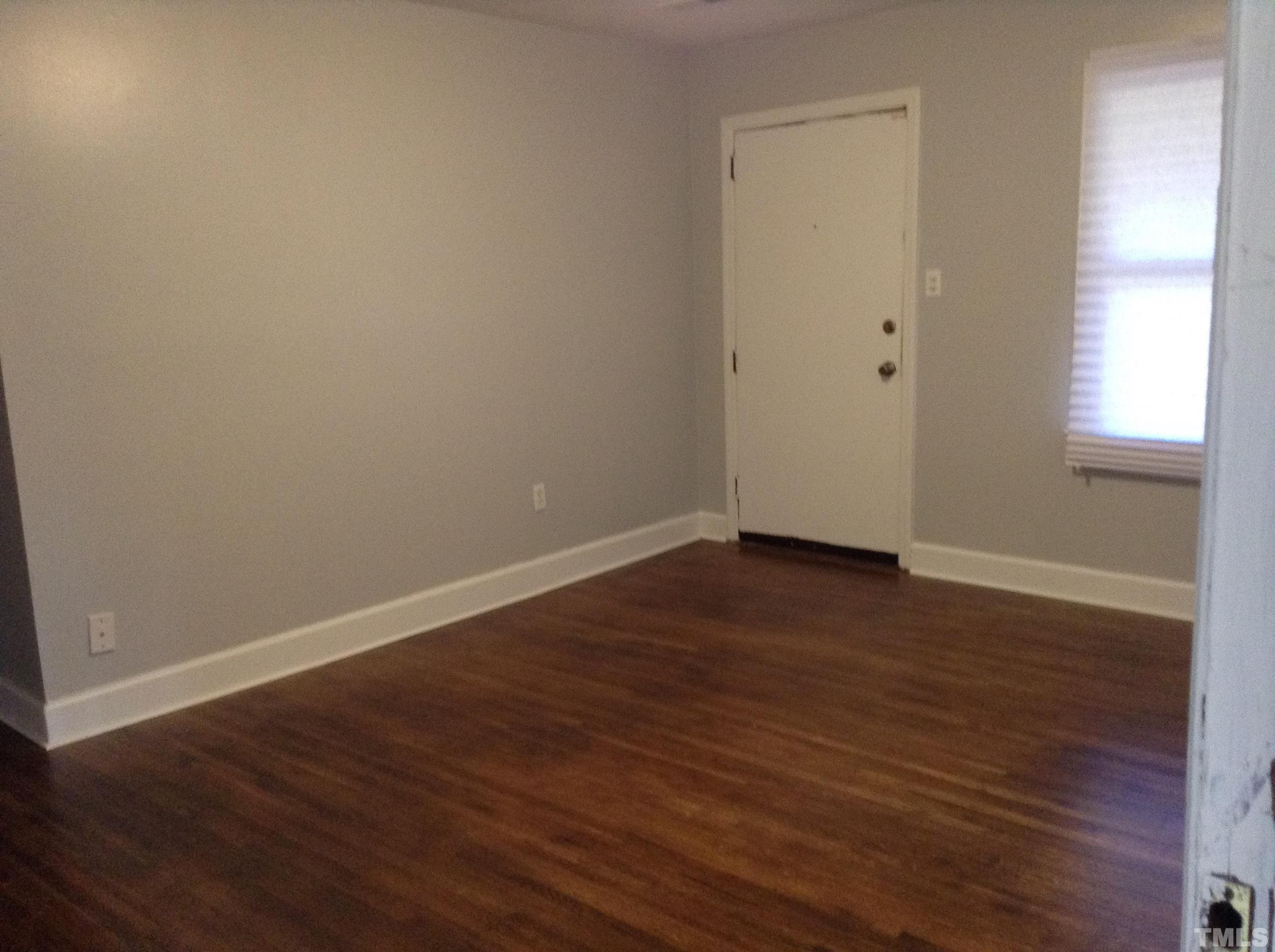 3901 Rock Quarry Road Raleigh, NC 27610 - Photo 5 of 10 a view of an empty room with wooden floor and a window