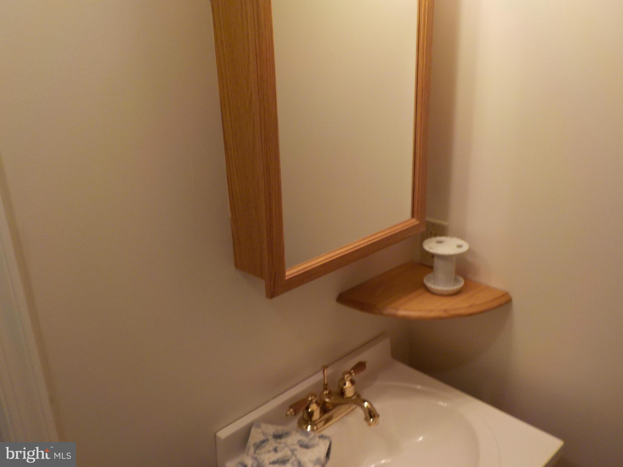 5437 Channing Road Baltimore, MD 21229 - Photo 19 of 25 a bathroom with a sink and a mirror