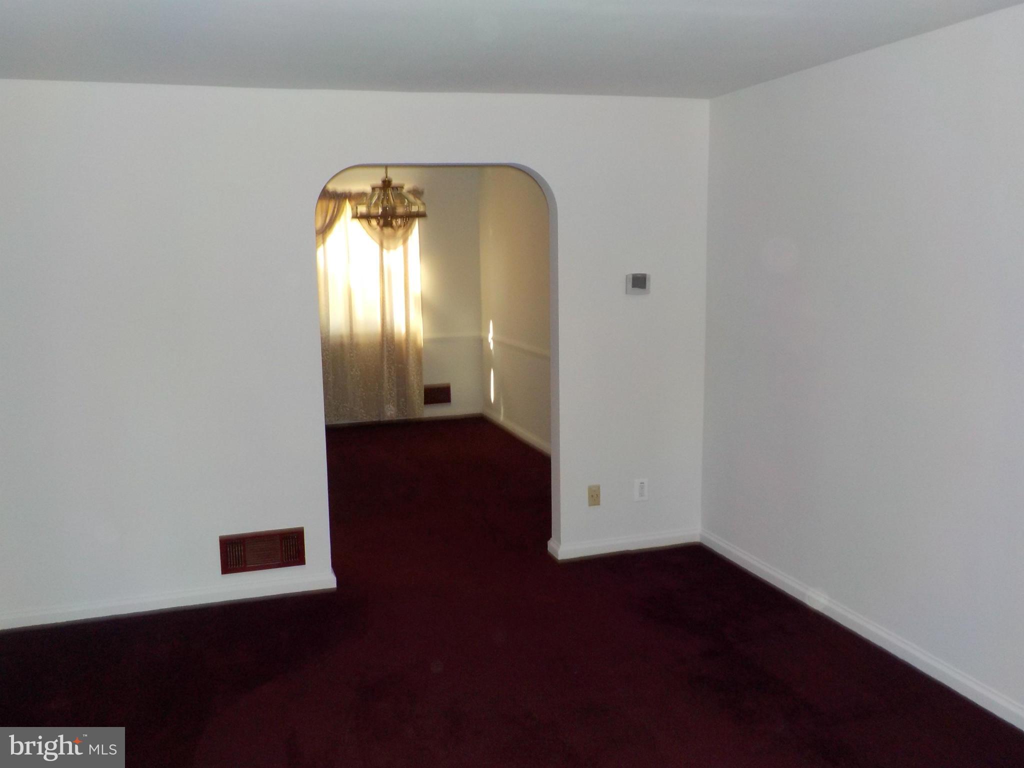 5437 Channing Road Baltimore, MD 21229 - Photo 3 of 25 an empty room with wooden floor and windows