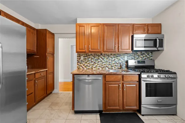 a kitchen with stainless steel appliances granite countertop a stove microwave and refrigerator
