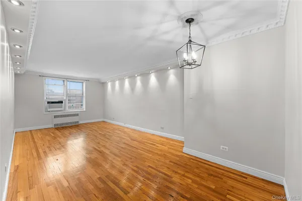 a view of empty room with wooden floor and windows