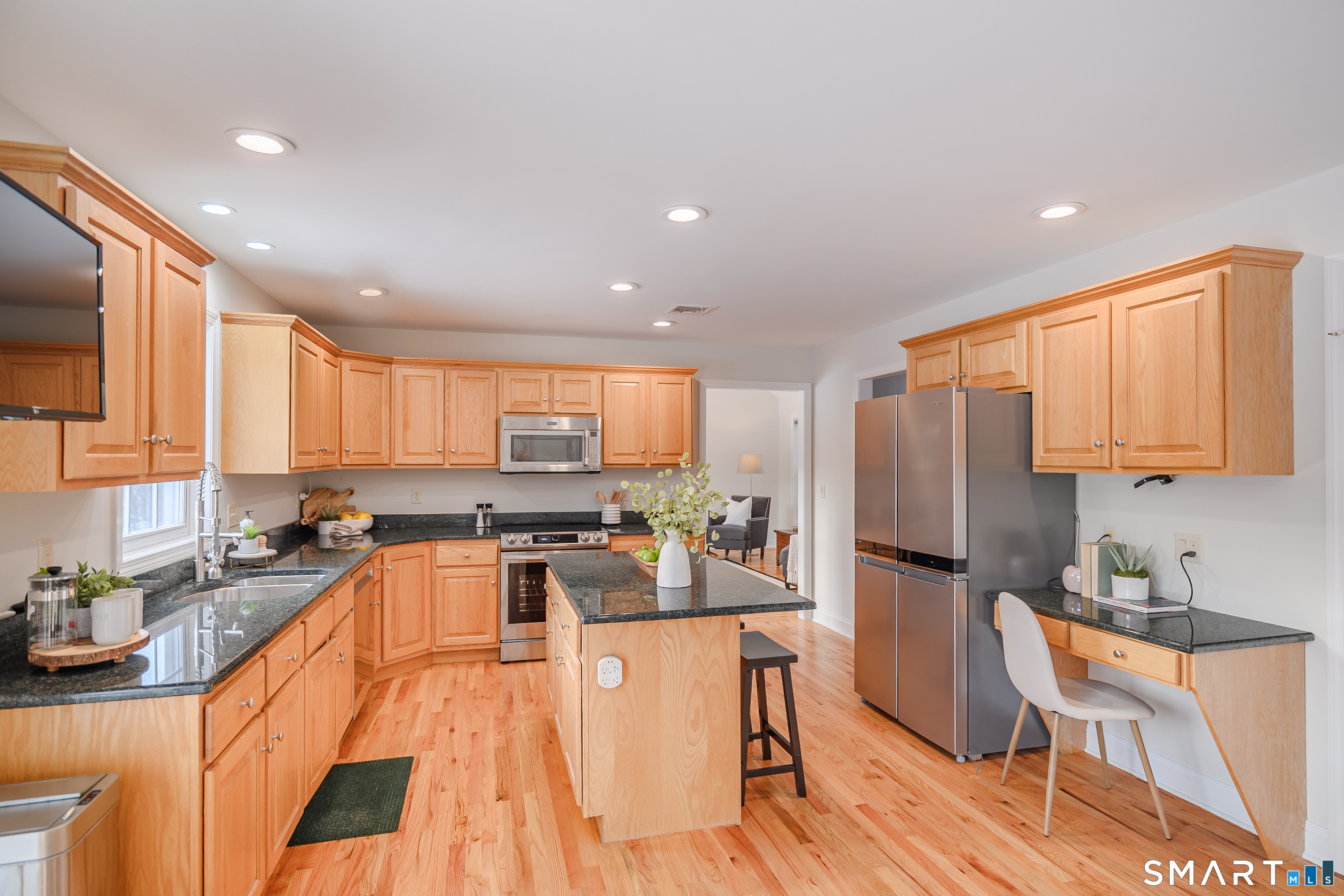 73 Dodgingtown Road Newtown, CT 06470 - Photo 19 of 39 a kitchen with granite countertop a refrigerator a sink dishwasher a stove top oven a dining table and chairs with wooden floor