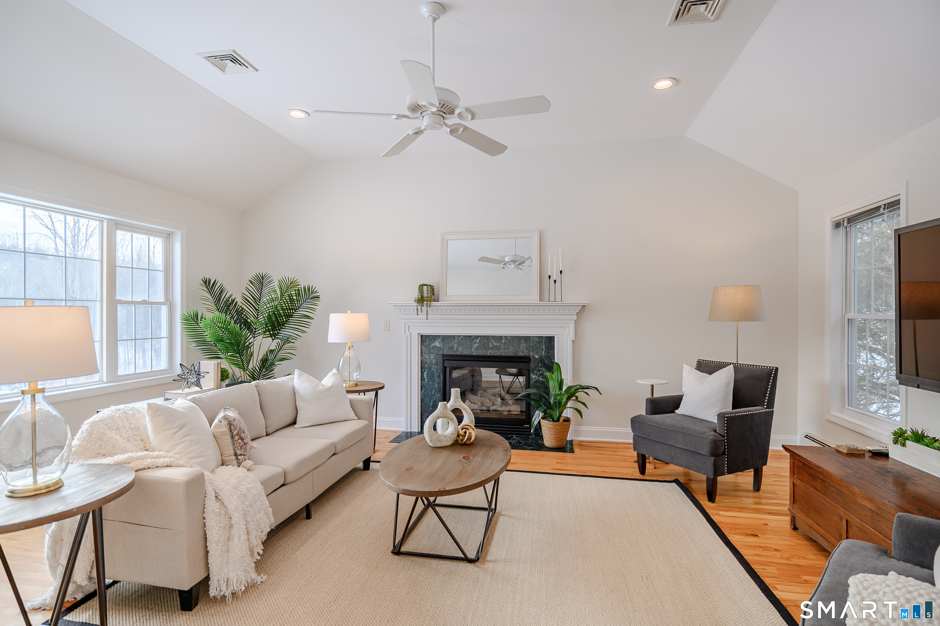 73 Dodgingtown Road Newtown, CT 06470 - Photo 33 of 39 a living room with furniture a fireplace and a flat screen tv