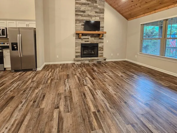 a view of empty room with wooden floor and fireplace