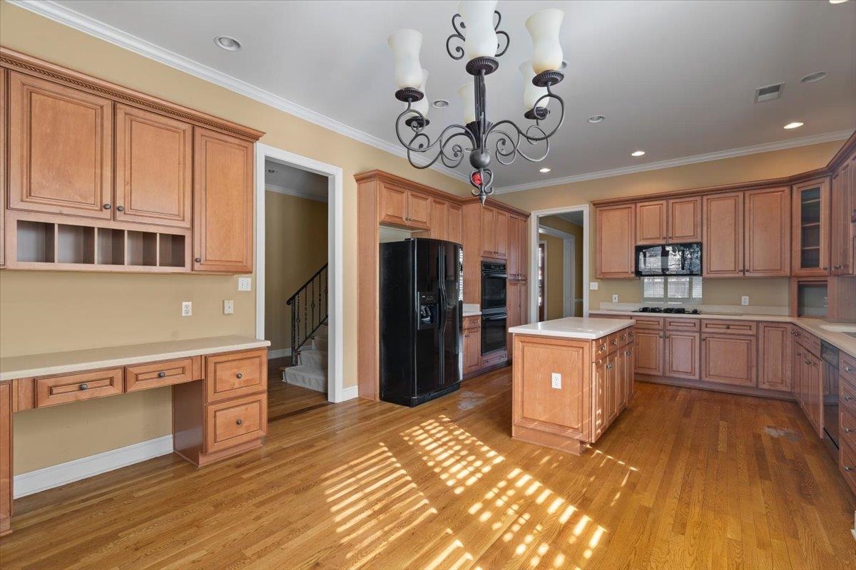 1435 Kimbrough Road Germantown, TN 38138 - Photo 15 of 34 a kitchen with stainless steel appliances granite countertop a refrigerator a sink dishwasher a stove and a dining table with wooden floor