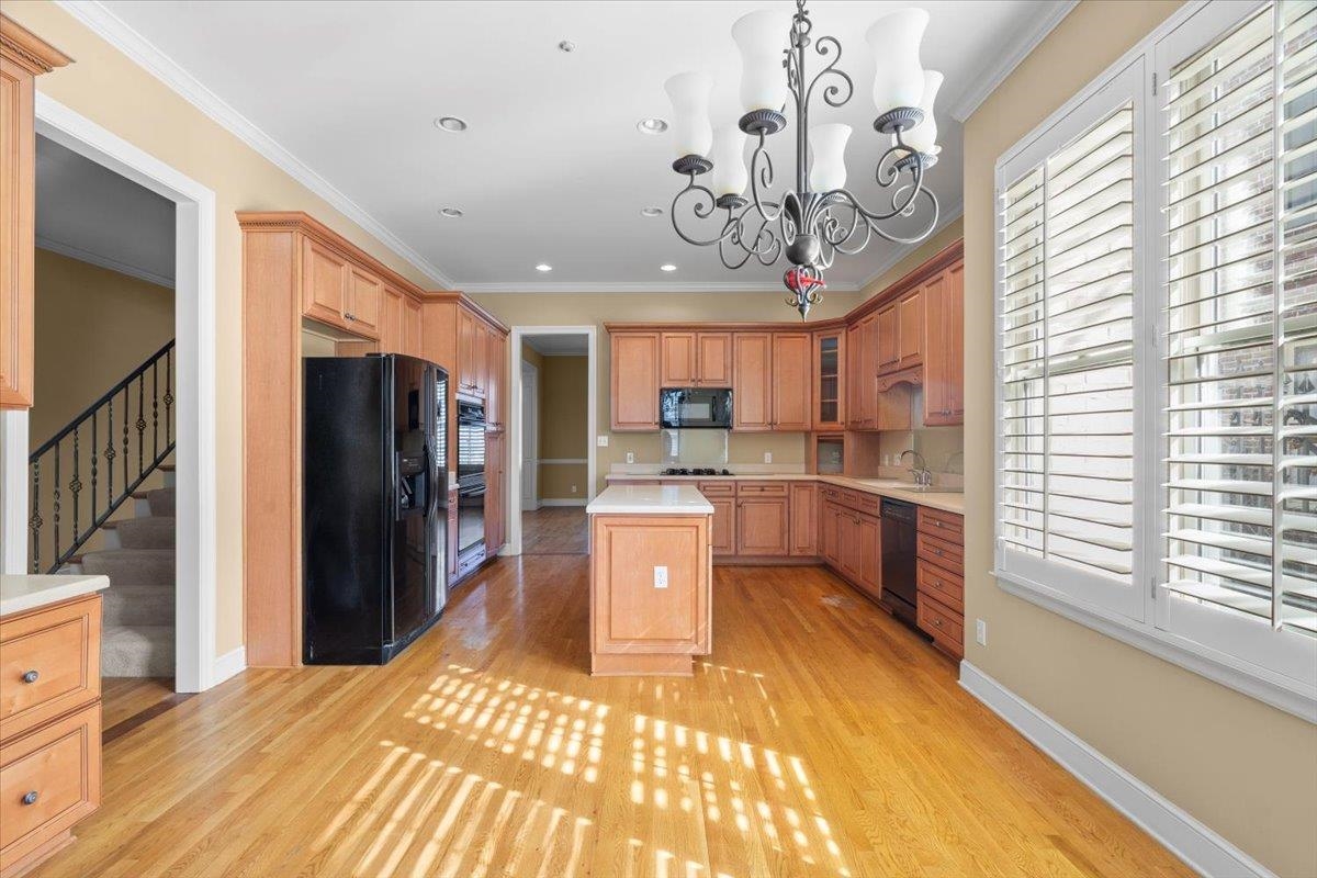 1435 Kimbrough Road Germantown, TN 38138 - Photo 17 of 34 a kitchen with stainless steel appliances granite countertop a refrigerator a sink dishwasher a stove and a dining table with wooden floor