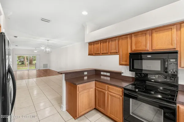 a kitchen with granite countertop a stove a sink and a microwave