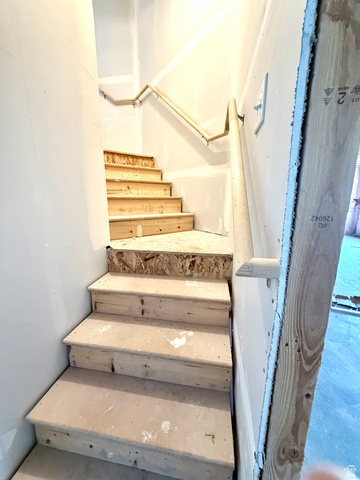 1823 South Longview Road Santaquin, UT 84655 - Photo 55 of 69 Stairwell featuring unfinished wood treads, a wood handrail, and drywall-ready walls
