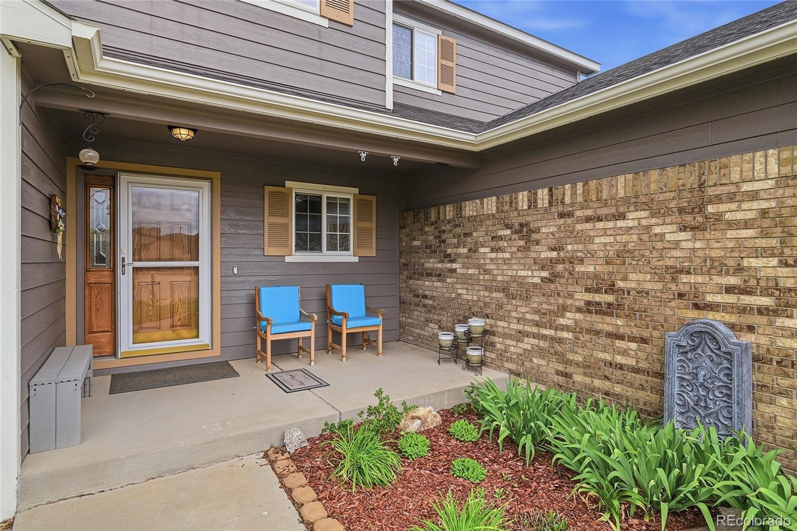 9288 Rockingham Drive Peyton, CO 80831 - Photo 4 of 49 a front view of a house with outdoor seating and plants