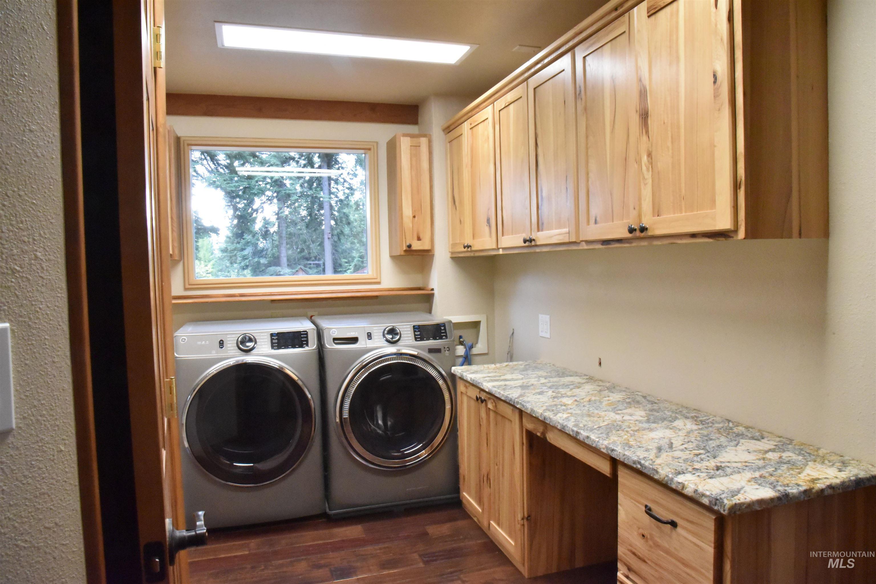 391457 Highway 95 Plummer, ID 83851 - Photo 13 of 39 Washroom with dark wood finished floors, washing machine and dryer, and cabinet space