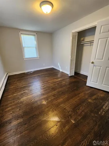 an empty room with wooden floor and closet