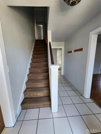 a view of a hallway with stairs and wooden floor