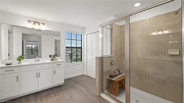 a bathroom with a double vanity sink a large mirror and a shower