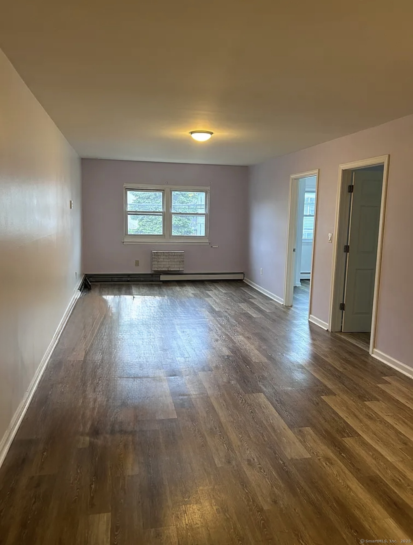 80 Taft Avenue, Unit 9 Bridgeport, CT 06606 - Photo 2 of 4 an empty room with wooden floor and windows