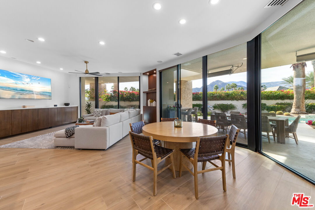 79400 Stonegate La Quinta, CA 92253 - Photo 11 of 46 a view of a dining room with furniture large windows and wooden floor