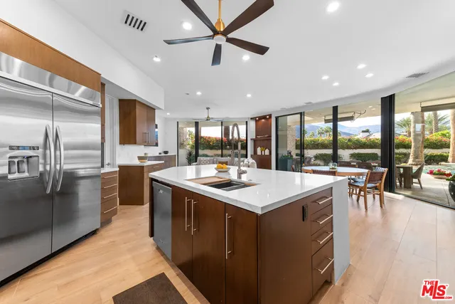 a kitchen with stainless steel appliances kitchen island granite countertop a sink and stove