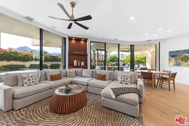 a living room with furniture and a large window with garden view