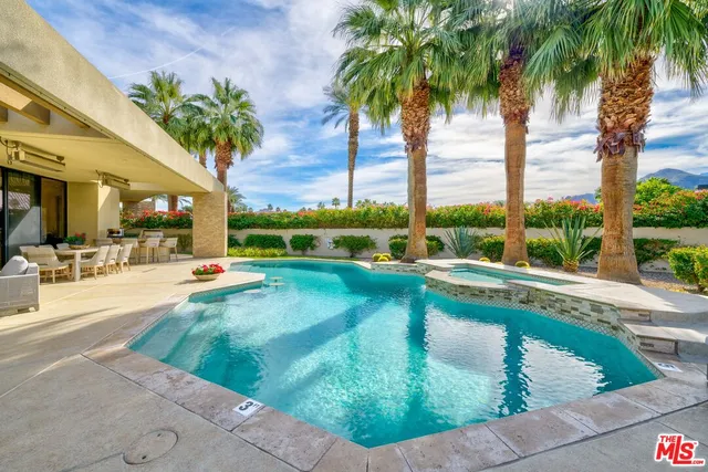 a view of swimming pool with a table and chairs
