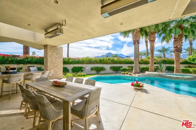 a view of an outdoor dining space with a table and chairs
