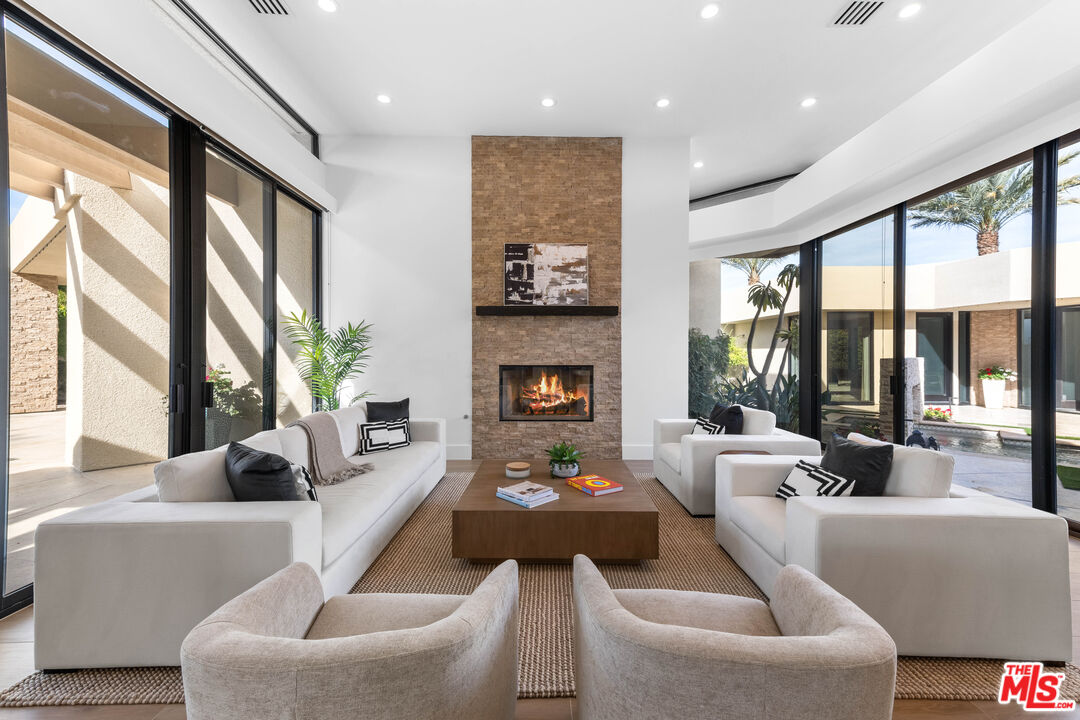 79400 Stonegate La Quinta, CA 92253 - Photo 8 of 46 a living room with fireplace furniture large windows and a fireplace