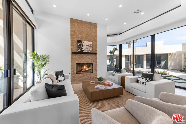 a living room with furniture fireplace and a large window