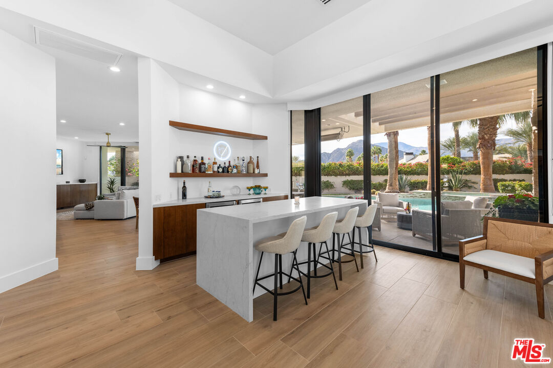 79400 Stonegate La Quinta, CA 92253 - Photo 10 of 46 a dining hall with stainless steel appliances granite countertop a stove top oven a dining table and chairs with wooden floor