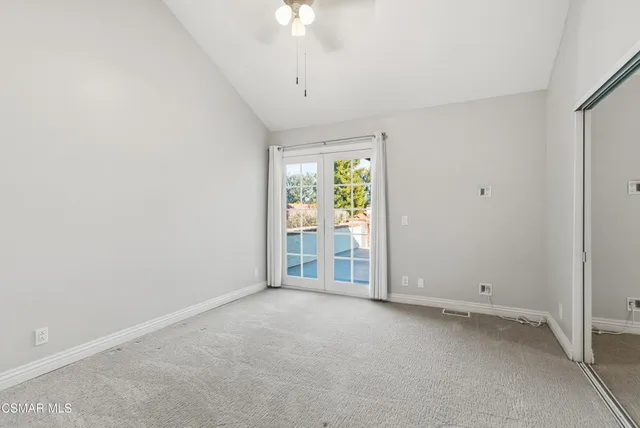 a view of a livingroom with a chandelier fan and windows