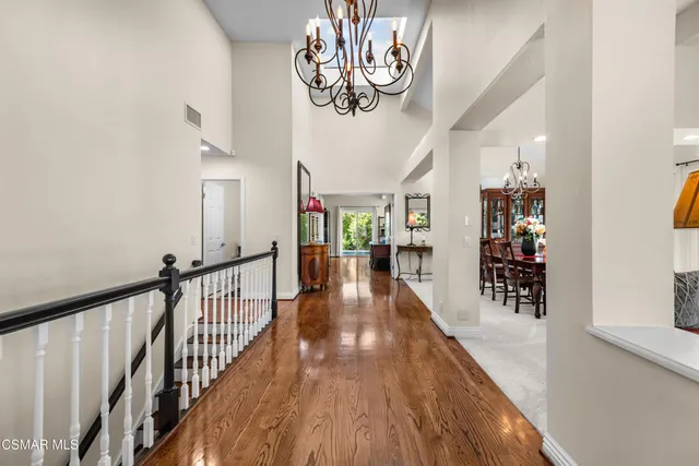 a view of a hallway with wooden floor and stairs