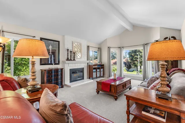 a living room with fireplace furniture and a large window