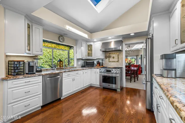 a kitchen with stainless steel appliances granite countertop a stove and cabinets