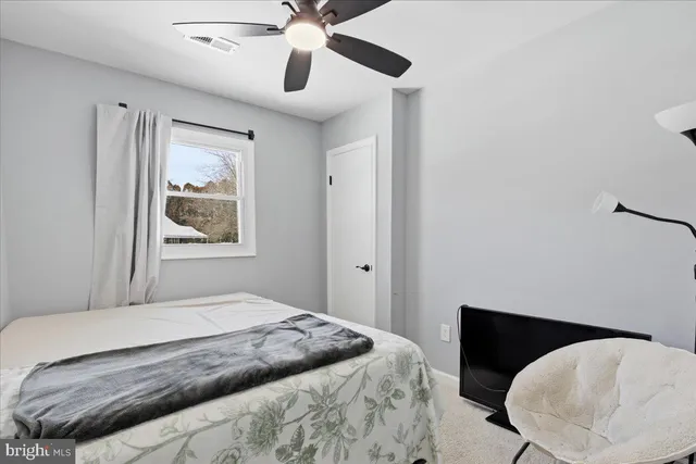 a bedroom with a bed and a painting on the wall