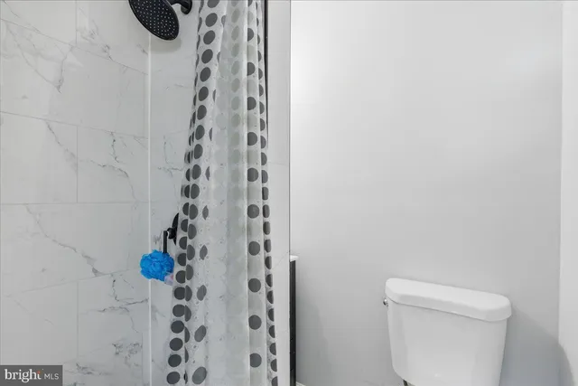 a bathroom with a toilet and shower curtain