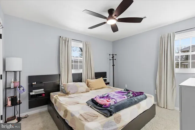 a bedroom with a bed a chandelier and a window